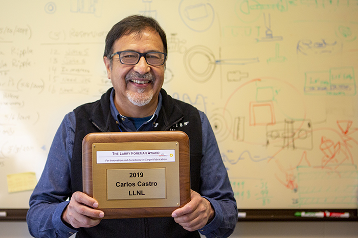 Photo of LLNL Senior Engineering Associate Carlos Castro holding his 2019 Larry Foreman Award