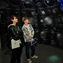 Two students stand inside a model of the NIF target chamber inside the Discovery Center. Credit: Garry McLeod