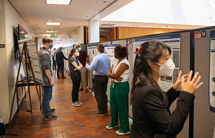 Student interns display their entries at the poster symposium last summer