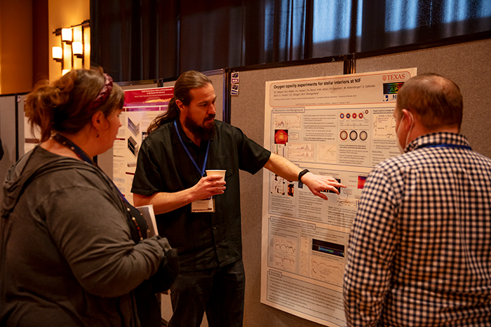 Daniel Mayes, a postdoctoral researcher from the University of Texas at Austin, explains his poster
